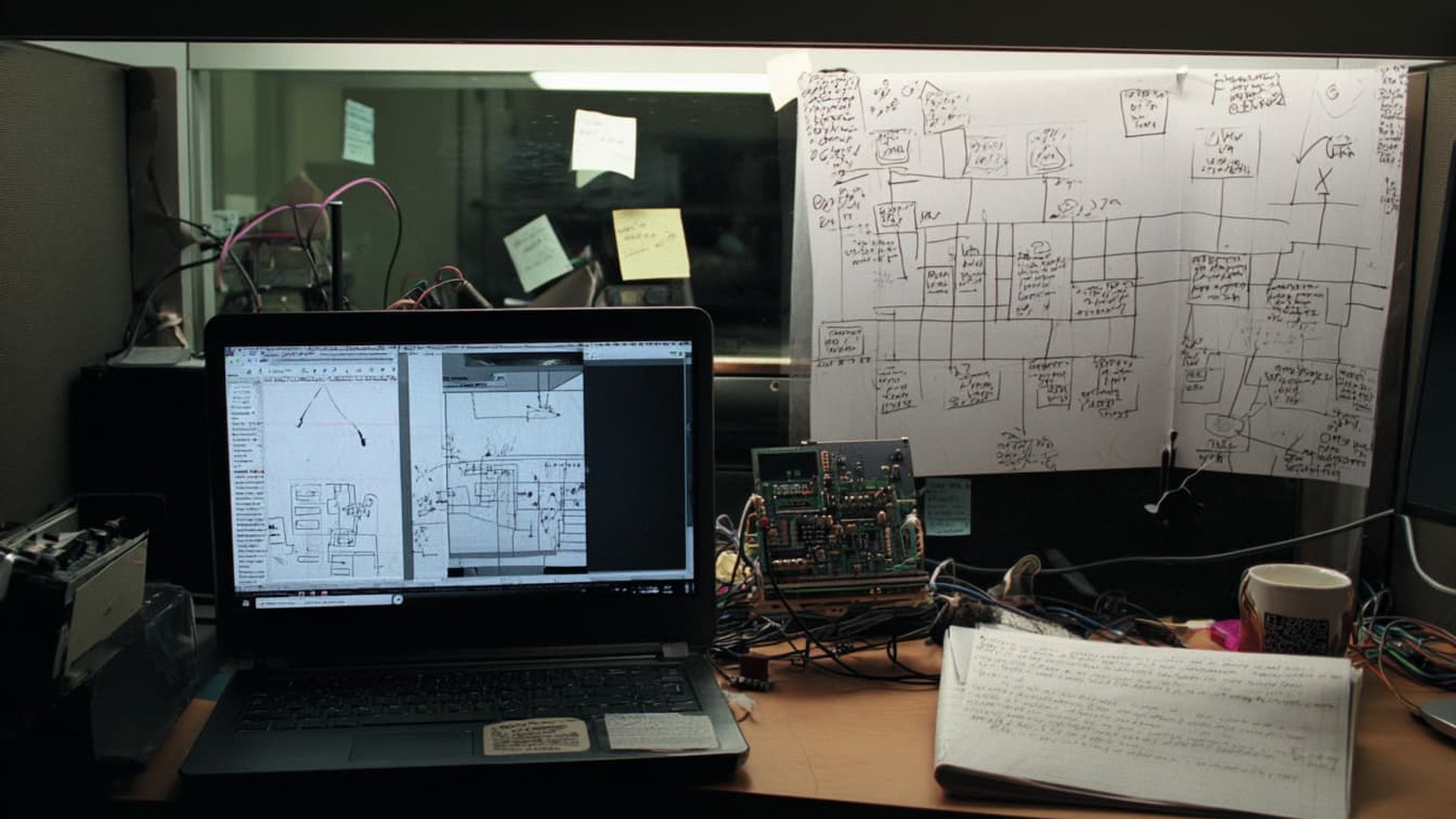 Engineer's workstation with laptop, circuit boards and handwritten diagrams - representing the technical depth of AI implementation in e-commerce