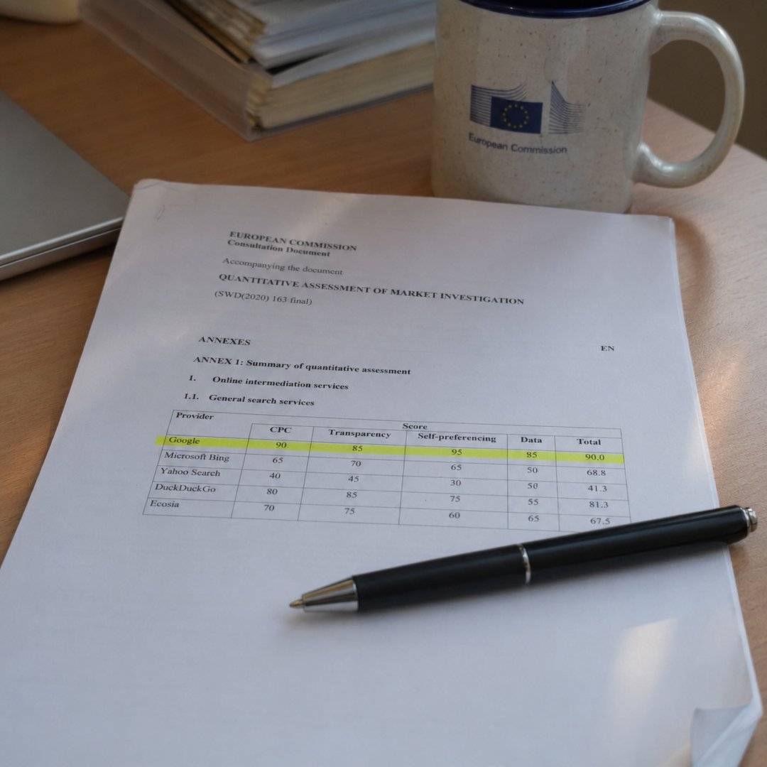 Printed European Commission consultation document on a desk corner with a yellow highlighter line across a provider rating row, a black ballpoint pen and a coffee mug at the upper edge of the frame