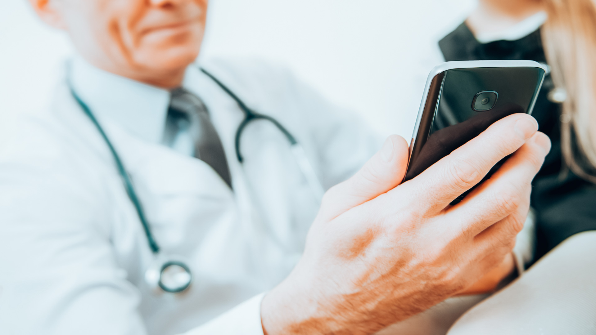 medical-doctor-looking-at-his-smartphone-device